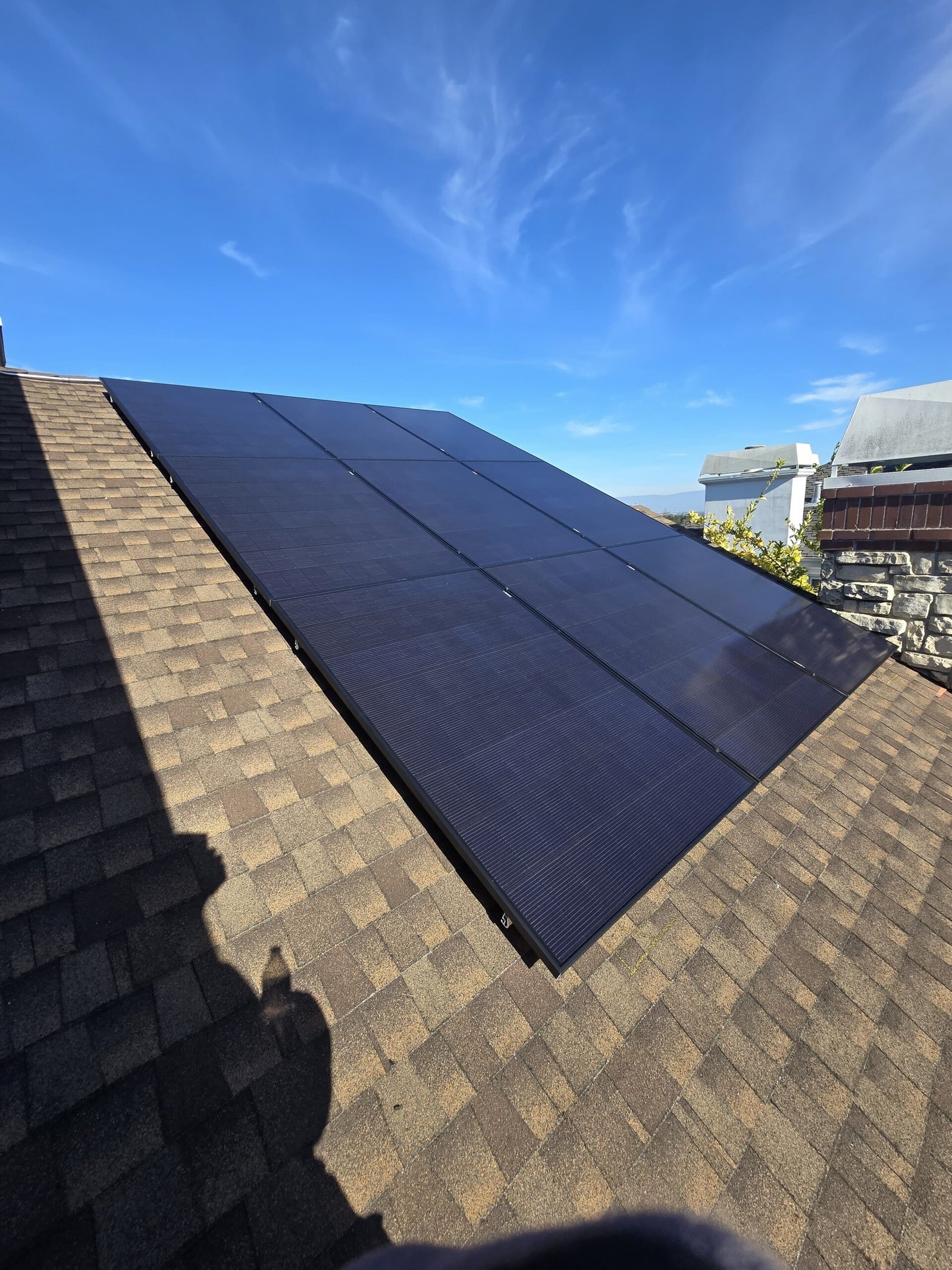 Close-up angled view of solar panels installed on a shingle roof